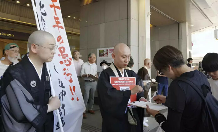 Buddhisten protestieren gegen Shinkansen. Bild: Kyodo Folge 359: Erdbeben-Panik wegen Manga, protestierende Buddhisten, Nudeln statt Reis, Rekord-Einnahmen durch Inflation, Trump droht mit Zöllen, Oberhauswahl und Rechtsruck